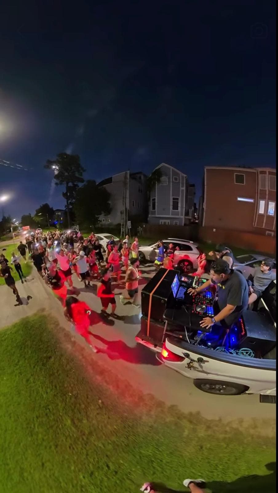 A night AM Club run passing a DJ playing from the back of a truck