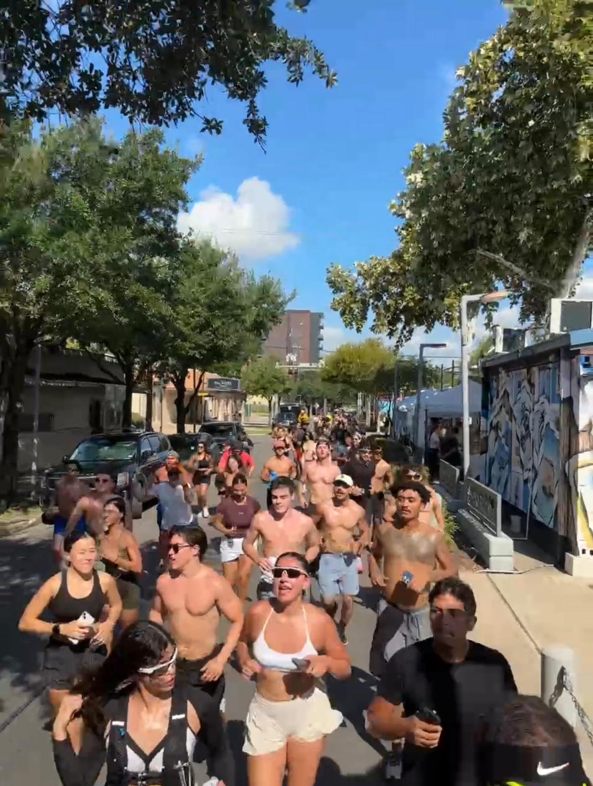Runners coming toward the camera on a tree-lined Houston street